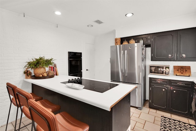 kitchen featuring black appliances and a breakfast bar area