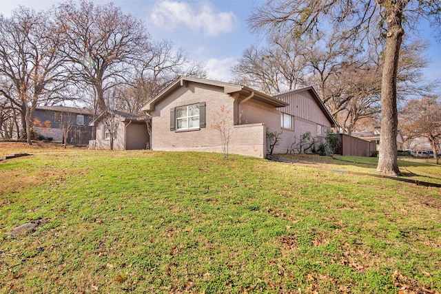 view of front of property with a front yard, brick siding, and fence