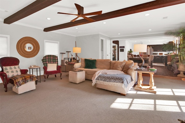 living room featuring beamed ceiling, light colored carpet, ceiling fan, and ornamental molding