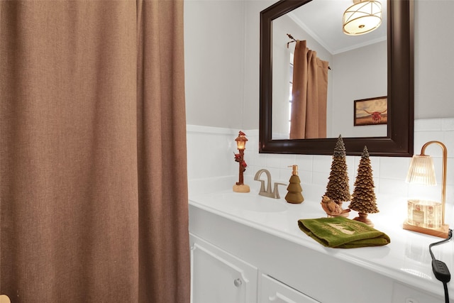 bathroom with backsplash, vanity, and ornamental molding