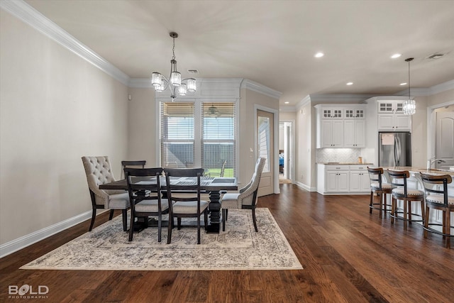 dining room featuring ornamental molding, sink, an inviting chandelier, and dark hardwood / wood-style flooring