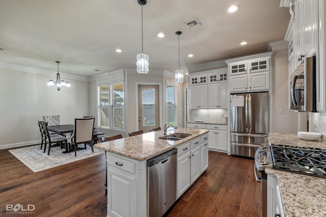 kitchen with pendant lighting, sink, appliances with stainless steel finishes, a kitchen island with sink, and white cabinets