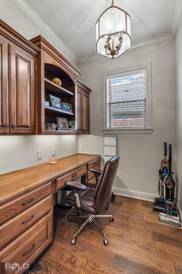 office space with a notable chandelier, built in desk, ornamental molding, and dark hardwood / wood-style floors