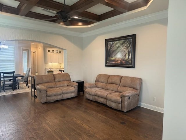 living room with coffered ceiling, ceiling fan, crown molding, dark wood-type flooring, and beam ceiling