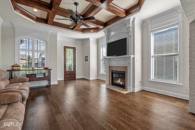 living room with coffered ceiling, a tiled fireplace, crown molding, and dark hardwood / wood-style floors