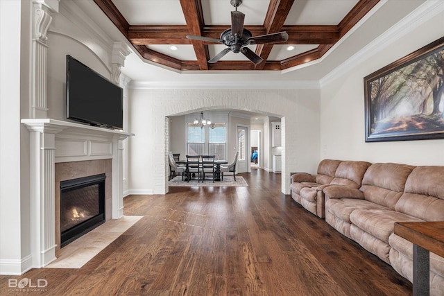 living room with hardwood / wood-style floors, a tiled fireplace, coffered ceiling, crown molding, and beam ceiling