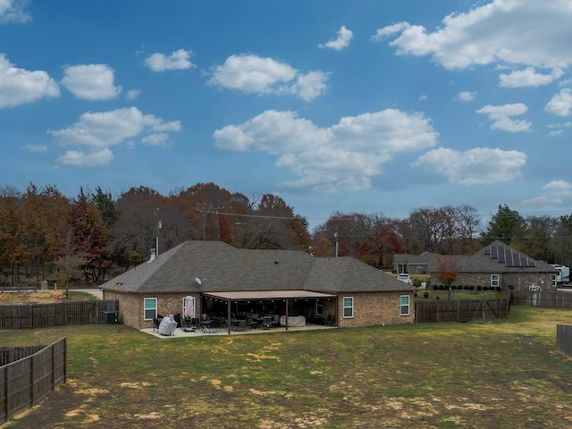 rear view of house with a yard and a patio