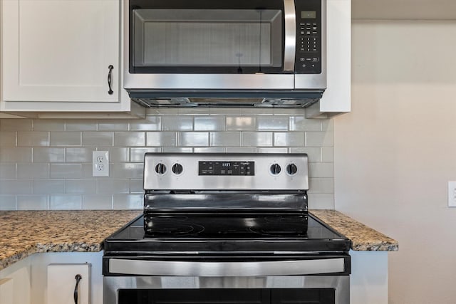 kitchen with stone counters, white cabinetry, backsplash, and appliances with stainless steel finishes