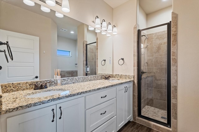 bathroom with vanity, hardwood / wood-style flooring, and a shower with door