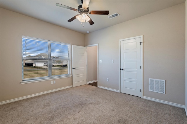 unfurnished bedroom featuring light colored carpet and ceiling fan