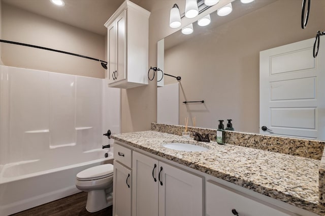 full bathroom with bathtub / shower combination, vanity, hardwood / wood-style flooring, and toilet