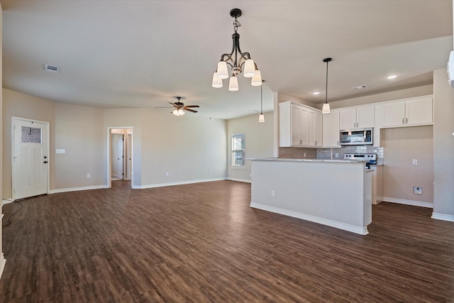 kitchen with white cabinetry, dark hardwood / wood-style flooring, light stone counters, and ceiling fan with notable chandelier