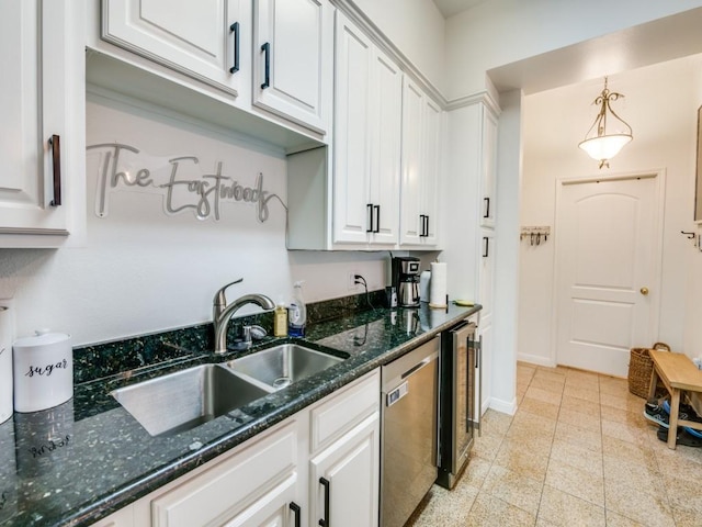 kitchen featuring pendant lighting, white cabinetry, stainless steel dishwasher, and sink