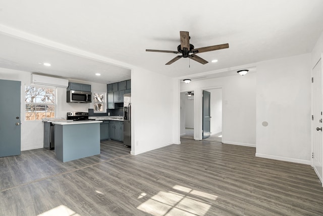 kitchen with gray cabinets, a kitchen island, wood-type flooring, ceiling fan, and stainless steel appliances