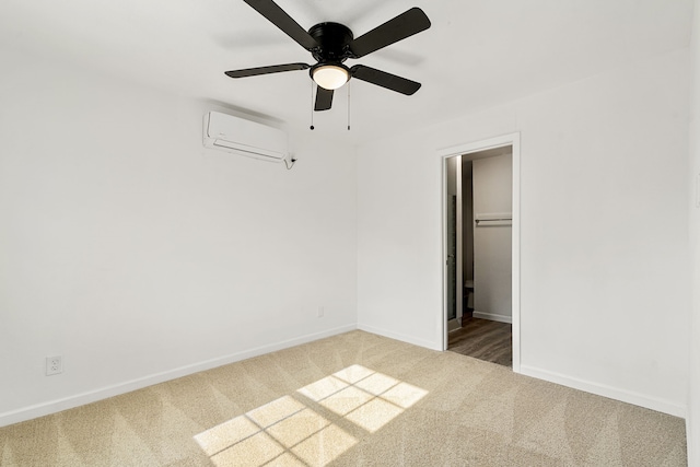 unfurnished bedroom featuring ceiling fan, a wall mounted AC, and carpet