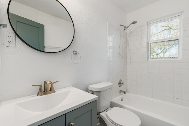 full bathroom featuring vanity, tiled shower / bath, and toilet