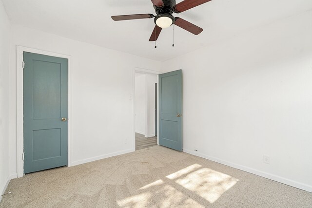 spare room featuring light carpet and ceiling fan