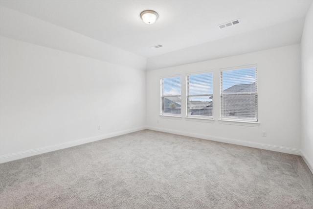 spare room with lofted ceiling, carpet flooring, and a wealth of natural light