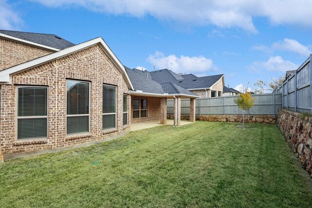 back of house featuring a yard and a patio