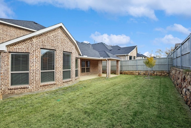 rear view of property featuring a lawn and a patio area