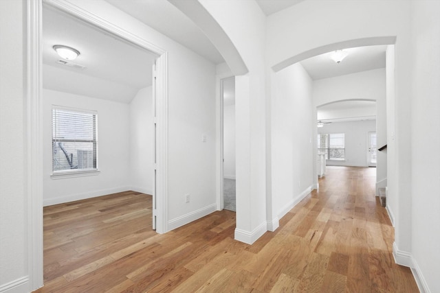 hall with plenty of natural light and light hardwood / wood-style floors