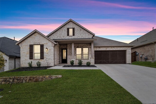 view of front of home with a lawn and a garage