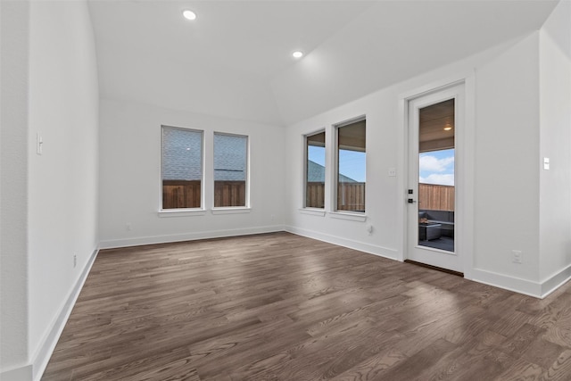 unfurnished room featuring dark wood-type flooring and lofted ceiling