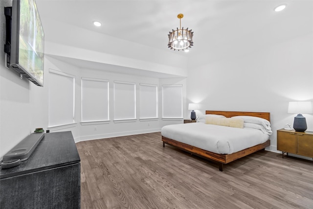 bedroom featuring an inviting chandelier and hardwood / wood-style flooring