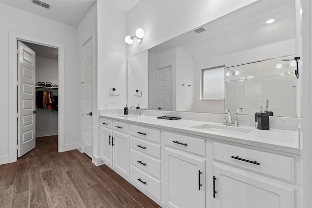 bathroom featuring vanity, tiled shower, and hardwood / wood-style floors