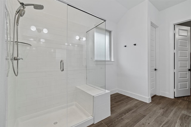 bathroom with vaulted ceiling, hardwood / wood-style floors, and an enclosed shower