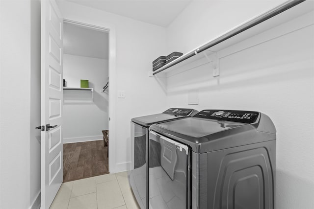 washroom featuring washing machine and dryer and light tile patterned flooring