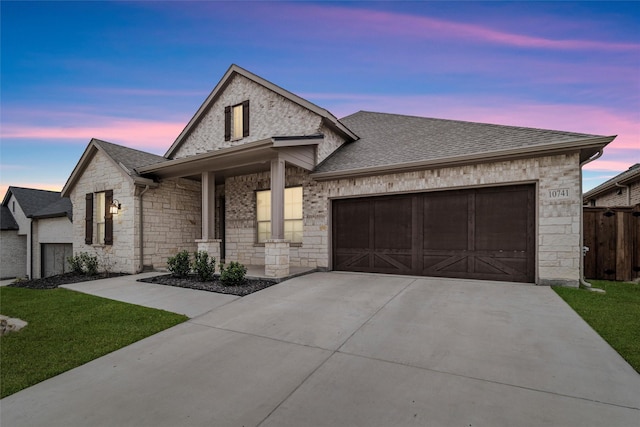 french country style house featuring a yard and a garage