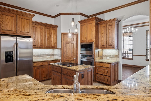 kitchen with arched walkways, brown cabinetry, light stone counters, stainless steel appliances, and a sink