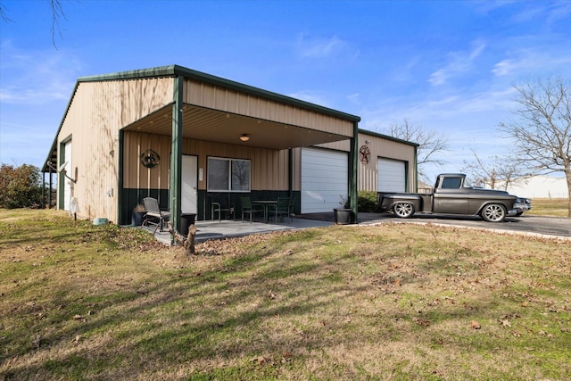 view of front of house with a garage, an outdoor structure, and a front yard