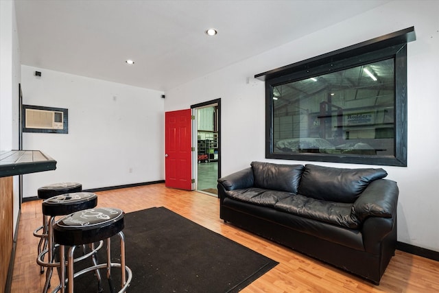 living room with baseboards, wood finished floors, and recessed lighting