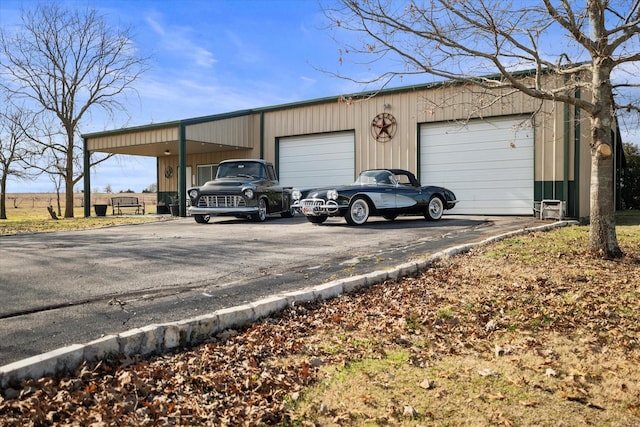 exterior space with a detached garage and aphalt driveway