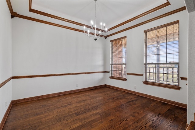 empty room with a notable chandelier, dark wood-type flooring, ornamental molding, and a wealth of natural light