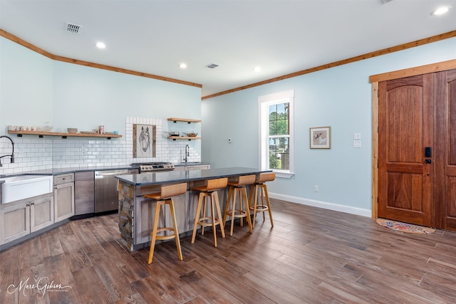 kitchen featuring a kitchen bar, dishwasher, sink, and decorative backsplash