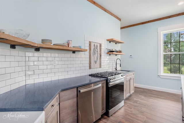 kitchen with stainless steel appliances, plenty of natural light, sink, and backsplash