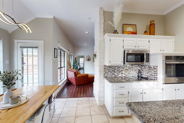 kitchen featuring light stone countertops, appliances with stainless steel finishes, decorative light fixtures, light hardwood / wood-style flooring, and white cabinets