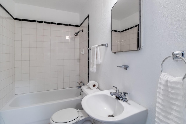 full bathroom featuring toilet, tiled shower / bath, and sink