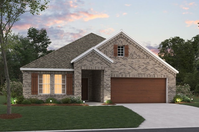 view of front of home featuring a garage and a yard