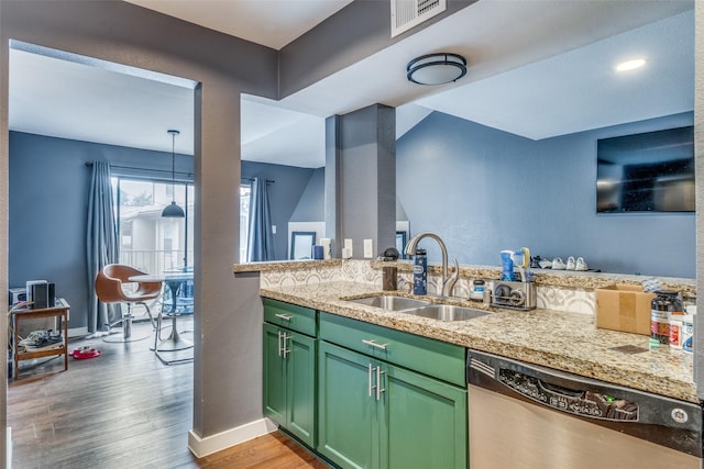 kitchen featuring dishwasher, green cabinets, sink, hanging light fixtures, and light hardwood / wood-style flooring