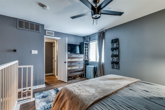 bedroom featuring wood-type flooring, a textured ceiling, ceiling fan, and radiator