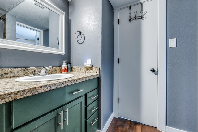 bathroom with vanity, a textured ceiling, and hardwood / wood-style flooring