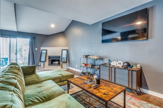 living room with a fireplace, wood-type flooring, and lofted ceiling