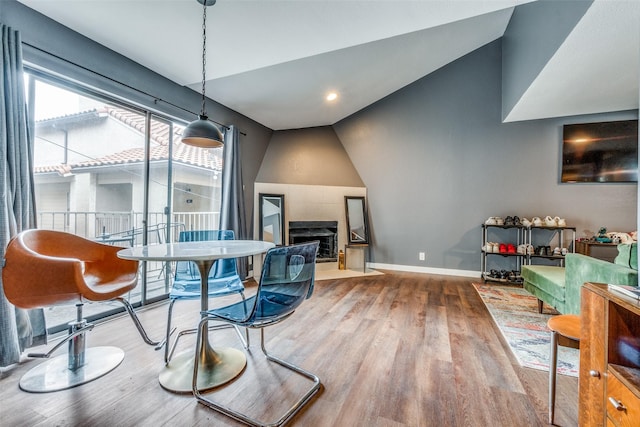 dining space with hardwood / wood-style floors and vaulted ceiling