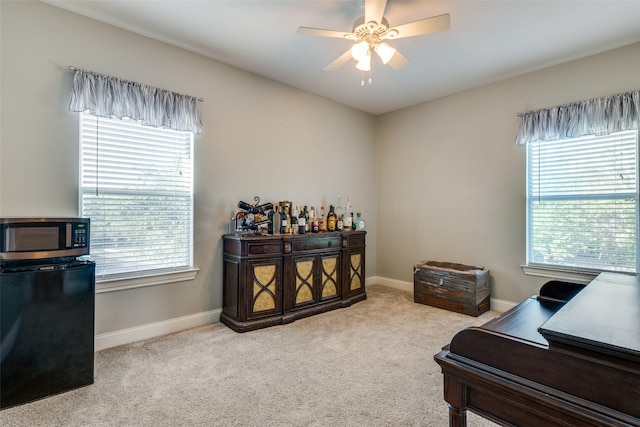 office space featuring ceiling fan, plenty of natural light, and light carpet