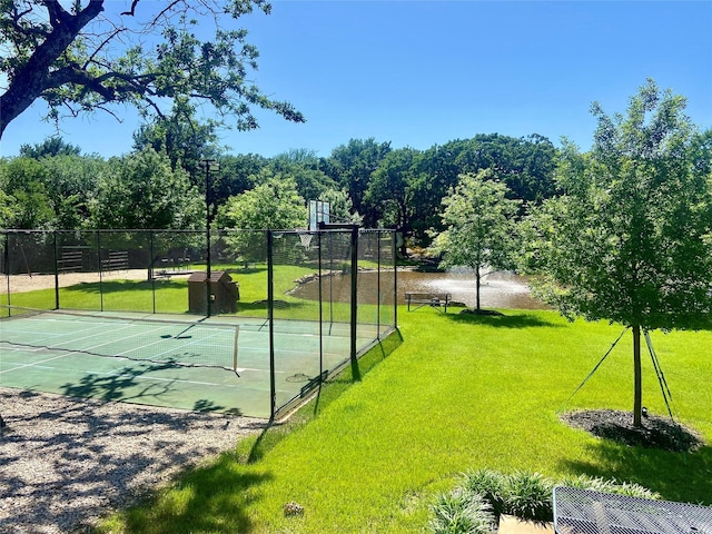 view of basketball court featuring a yard and a water view