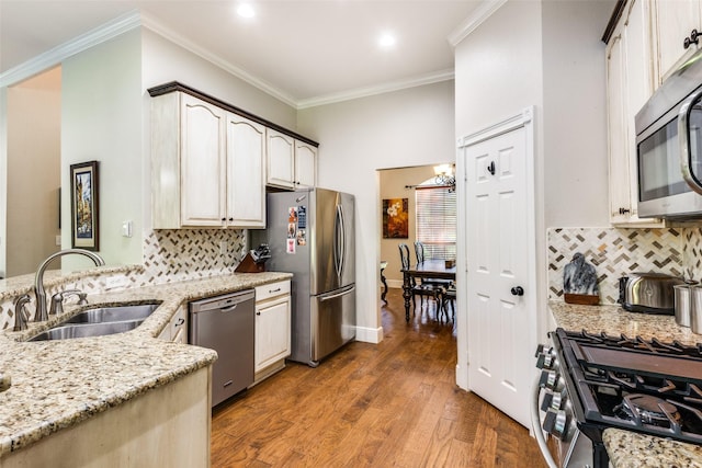 kitchen featuring appliances with stainless steel finishes, sink, crown molding, light stone countertops, and dark wood-type flooring